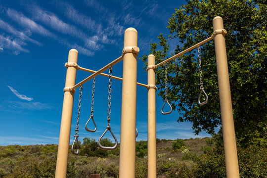 Gymnastics rings at park on sunny day with blue sky