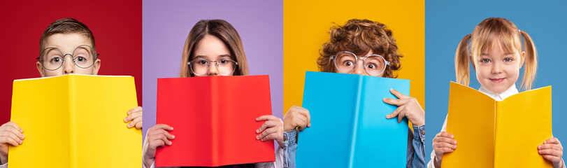 Fototapeta Cute schoolgirls and schoolboys hiding faces with books obraz