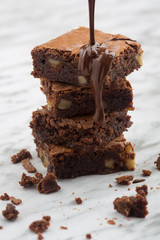 Delicious tower of classic chocolate brownies with walnuts and melted chocolate.
