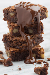 Delicious tower of classic chocolate brownies with walnuts and melted chocolate.