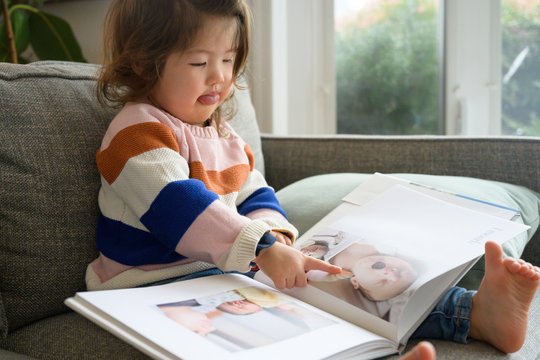 Little girl looking at baby book