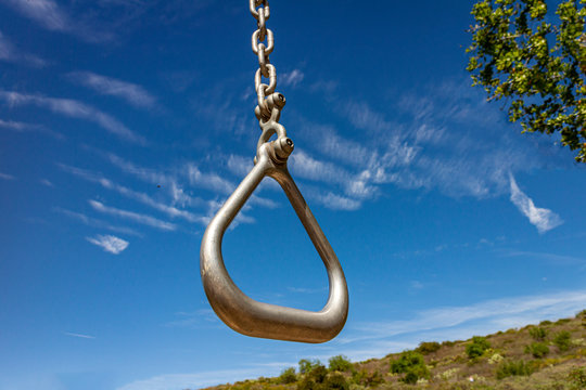 &ccedil;lose up of gymnastics ring at park on sunny day with blue sky