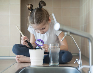 School child holding in hand magnifying glass. Earth Day. World Environment Day. Environmental education. Distance learning. Remote home education. Homeschooling - quarantine (coronavirus pandemic)