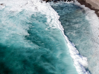 Aerial drone view of spashing waves in blue ocean