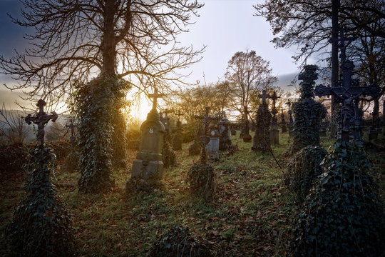 Abandoned and decayed graveyard at sunset