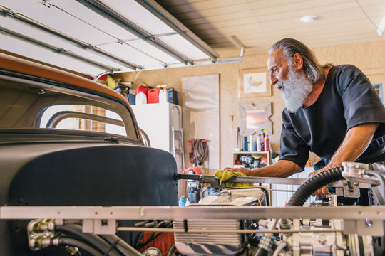 Retired Senior Citizen Working on his Custom Car Hobby