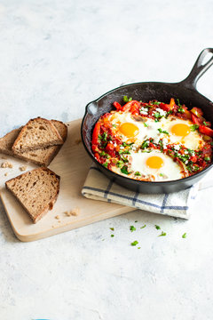 Shakshuka in a skillet with some bread