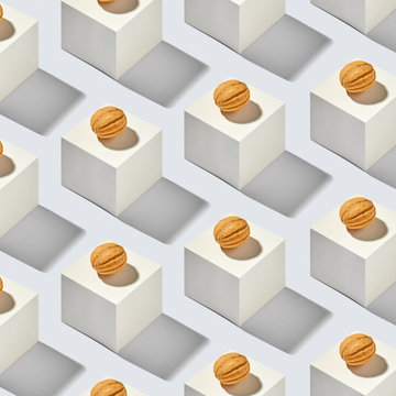 Creative cubes pattern with walnuts cakes on a gray background.