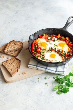 Shakshuka in a skillet with some bread