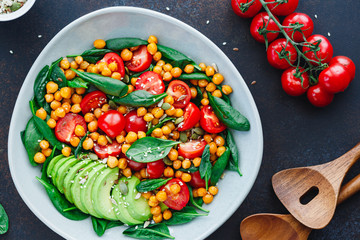Fresh healthy salad with chickpea, avocado, cherry tomatoes and spinach.