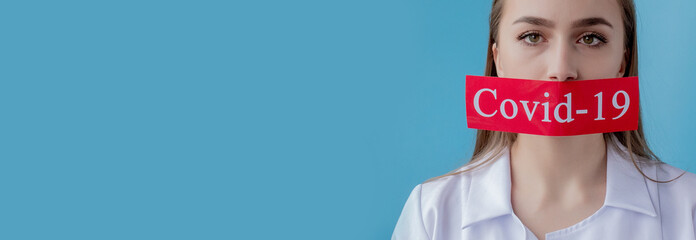 Doctor woman pointing to red paper with mesaage Coronavirus on blue background. World Health...