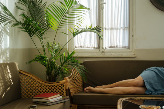 Young woman lying on sofa in cozy room