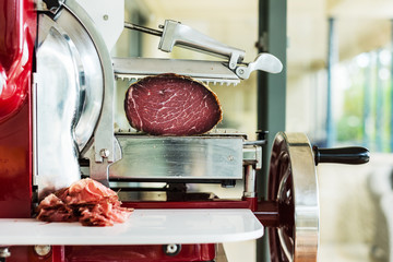 slicing meat on a vintage rotary slicer