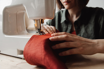 Female tailor using manual sewing machine.