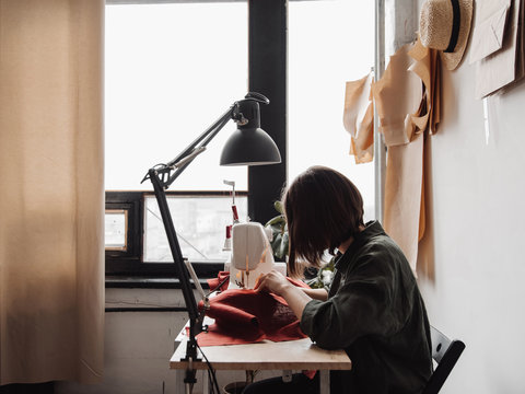 Woman dressmaker using sewing machine.