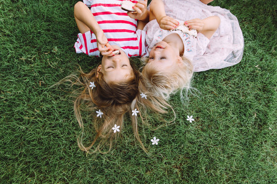 Two little girls lying on the grass
