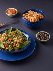 fried rice with vegetables in a blue plate.