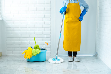 Housekeeping and cleaning concept, Happy young woman in blue rubber gloves wiping dust using mop while cleaning on floor at home