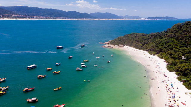 Imagem aerea de ilha com barcos ancorados praia cheia e o continente nofundoIlha do Campeche