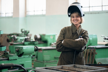 Woman welder with a welding torch in her hands.