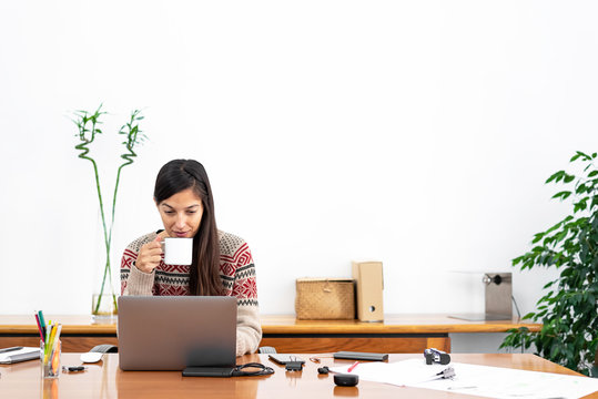 Young Freelancer Working From A Makeshift Home Office Connected To The Internet With A Laptop And A Phone During The Period Of Global Confinement