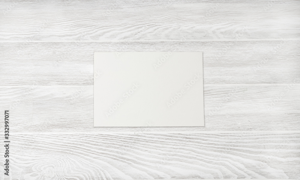 Wall mural blank sheet paper on white wooden table. white wood background.