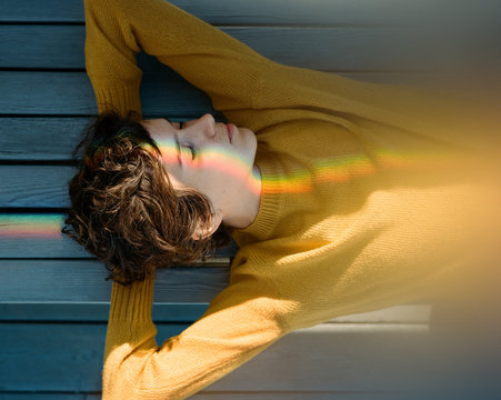 Stylish Portait Of Young Pretty Girl With Rainbow Glare On The Face