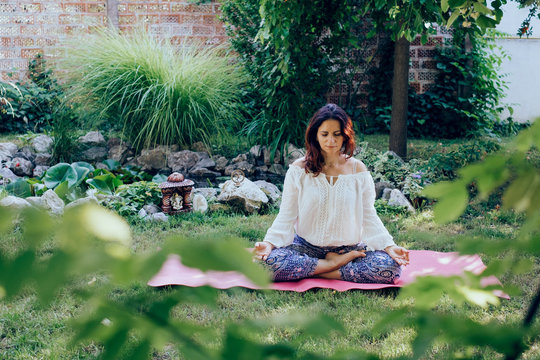 Woman Meditating in her backyard