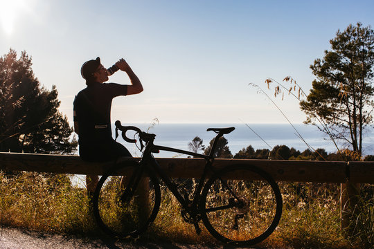 Anonymous Road Cyclist Taking Break and Drinking