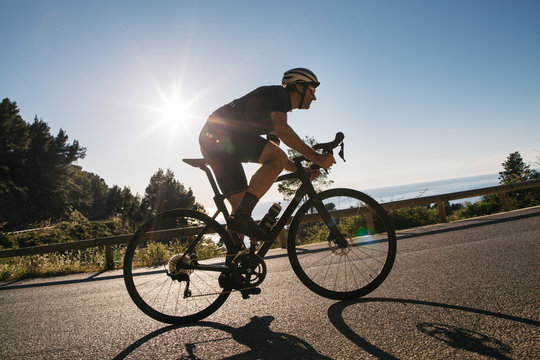 Caucasian Man On Road Bike Racing Uphill