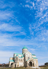 Panoramic background image of Bagrati Kutaisi cathedral and blue beautiful sky and tourists.Georgian churches. 2020