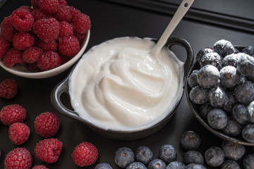 Greek yogurt in bowl with spoons,Healthy breakfast with Fresh greek yogurt, muesli and berries on background