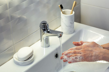 Hygiene concept. Washing hands with soap under running water