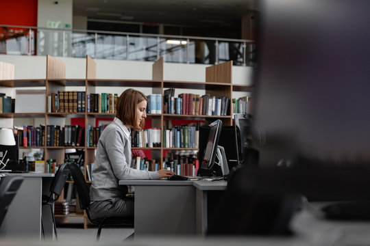 Woman working on computer in library