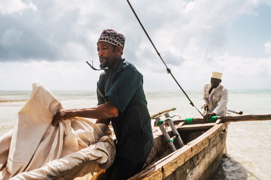 Zanzibari fishermen picking up the sail from the wooden boat
