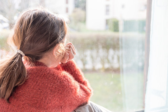Enfant boudant devant le fen&ecirc;tre