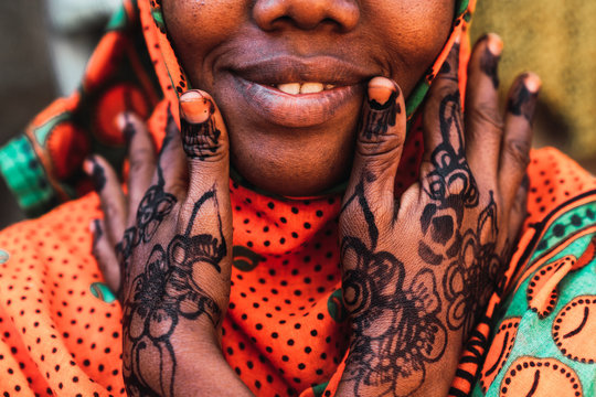 Close up of hands around the cheek of a zanzibari woman
