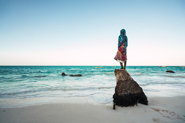 silhouette of a woman from behind on a wooden truck in front of