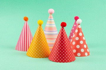 Colorful birthday caps on mint background.