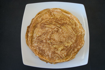 Frischer Crepe Pfannkuchen gestapelt auf weißem Teller