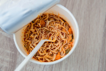 Hot noodle Cup. Noodle cup Ready made. Eating Instant Noodles with a Plastic Fork. Junk food Instant noodles are eating the popular food.