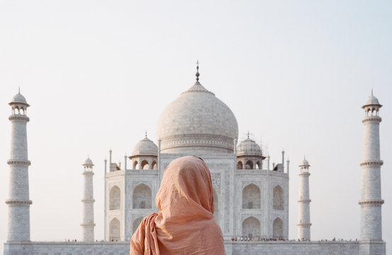 Young woman in traditional indian clothes in front of Taj Mahal in Agra, India