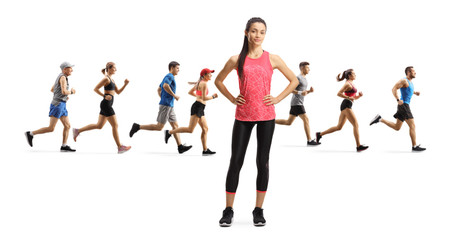 Young slim female in sportswear standing and people running in the back