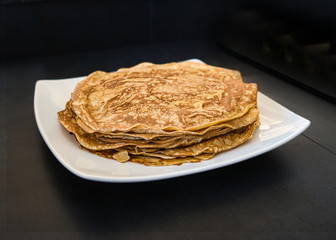 Dessert Nachspeise frischer Vollkorn Crepe Pfannkuchen beim braten in einer weißen Pfanne mit Rührschüssel