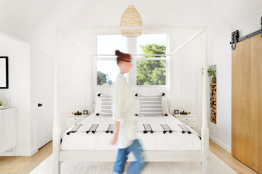 Woman walking through modern design farmhouse bedroom