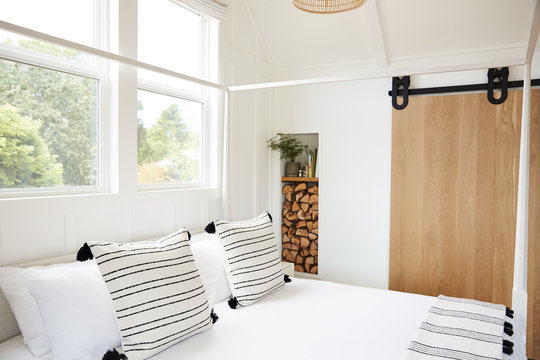 Designer pillows on canopy bed in modern farmhouse bedroom