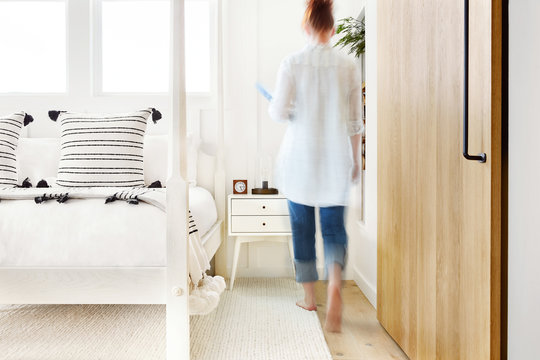 Woman walking through modern design farmhouse bedroom