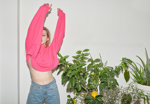 Crazy teen girl in pink top dancing near lemon tree.