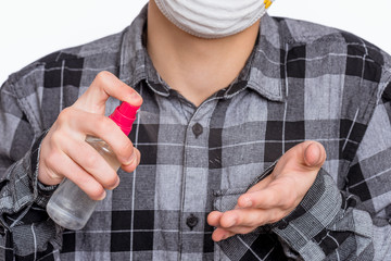 Fototapeta premium Concept of coronavirus quarantine. Child wearing medical protective mask applying an antibacterial antiseptic spray for hands disinfection and health protection during flu virus outbreak. COVID-19.