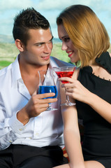 Beautiful couple having a cocktail or a drink in a bar